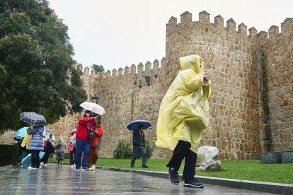 Fotografía de referencia, varias personas se protegen de la lluvia en España.