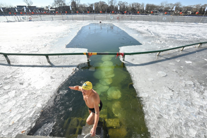 Un entusiasta de la natación invernal hace un gesto después de nadar en el lago Houhai del área escénica de Shichahai en Beijing el 20 de enero de 2026.
