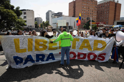 Un funcionario de la Policía Nacional Bolivariana bloquea el paso a familiares de presos políticos durante una protesta alrededor de El Helicoide este sábado 7 de febrero, en Caracas (Venezuela).