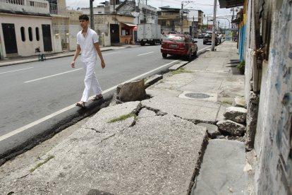 Los peatones deben caminar por la calzada debido al daño en la acera. Ocurre en Lizardo García y Colón, en el sur de Guayaquil.