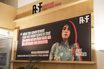 Un cartel muestra el retrato de la periodista iraní y premio nobel de la paz Narges Mohammadi en la sede de Reporteros sin Fronteras en París, Francia.