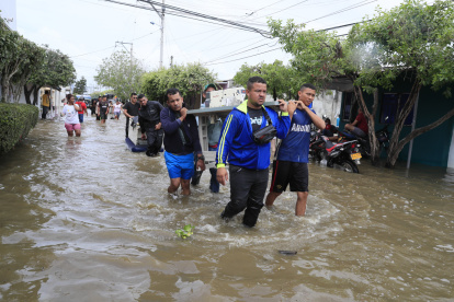 Personas intentan rescatar sus pertenencias, este sábado 7 de febrero, luego de una nueva creciente del río Sinú que afectó el barrio El Dorado en Montería.