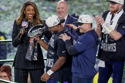 Kenneth Walker III (D) sostiene el trofeo Lombardi junto a Sam Darnold, su rival en la consecución del MVP.