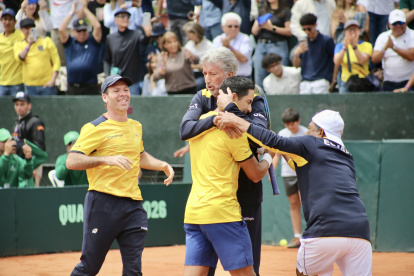El capitán del equipo nacional de Copa Davis, Raúl Viver (c) abraza al tenista Gonzalo Escobar, tras derrotar a Australia por 3-1