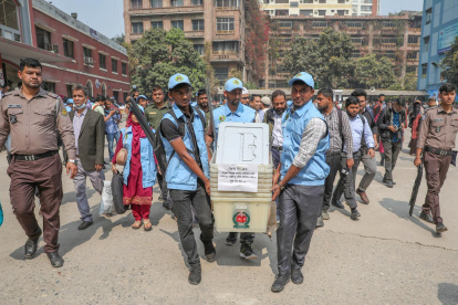 Personas trasladan el material para las elecciones en Daca, Bangladés.