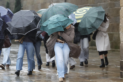 Varias personas se protegen de la lluvia en el noroeste de España.