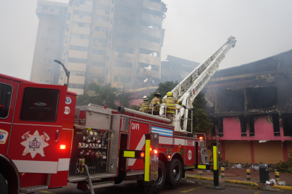 Los bomberos continúan sus labores en el sitio del incendio.
