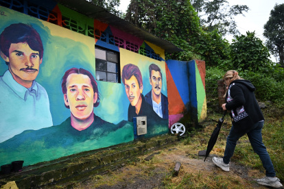 Otilia Torres, hermana de Diuviseldo Torres, camina frente a un mural que representa a su hermano y otras personas desaparecidas en el municipio de Fusagasugá.