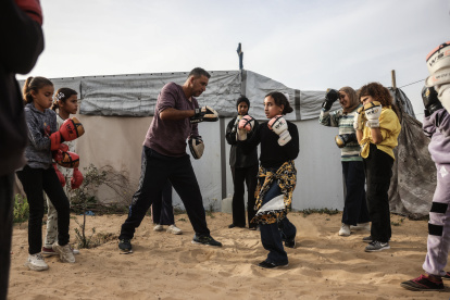 Actividad. Niñas y jóvenes palestinas asisten a una sesión de entrenamiento de boxeo entre tiendas.
