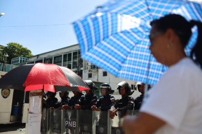 Integrantes de la Policía Nacional Bolivariana de Venezuela custodian durante una huelga de hambre de familiares de presos políticos este sábado, frente al centro penitenciario Zona 7 en Caracas (Venezuela). Familiares de presos políticos en Venezuela se unieron a una huelga de hambre iniciada por los detenidos, tras la liberación de 17 personas, incluidos sindicalistas y dos jóvenes con autismo. EFE/ Miguel Gutiérrez
