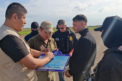 La Policía de Bolivia y el uruguayo Sebastián Marset (cd) antes de abordar un avión tras su captura en Santa Cruz (Bolivia).