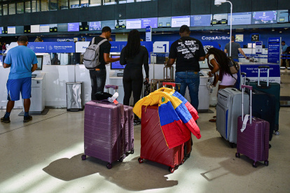 Un grupo de pasajeros alistan documentos en el aeropuerto.