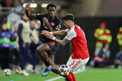 Piero Hincapié, defensa del Arsenal, disputa un balón contra Ernest Poku, jugador del Bayer Leverkusen.