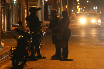 Un integrante de la Policía de Ecuador conversa con ciudadanos tras el toque de queda este domingo, en Guayaquil