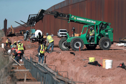 Obreros estadounidenses construyen un muro fronterizo, entre El Paso y Ciudad Juárez (México).