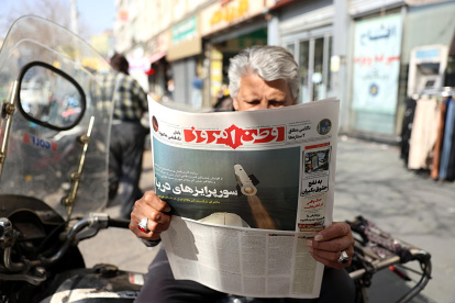 Mientras Estados Unidos continúa reforzando su presencia militar en Oriente Medio, un hombre lee el diario iraní  con el titular "Sorpresas marítimas".