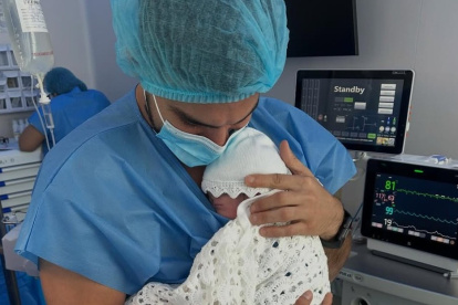 Carlos Scavone lleva en brazos a su hija.