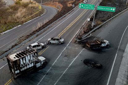 Automóviles y camiones quemados, incendiados por grupos del crimen organizado en respuesta a una operación para arrestar a un objetivo de seguridad de alta prioridad, en una carretera en el estado de Jalisco.