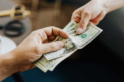 Referencial. La entrega de billetes refleja el pago de obligaciones laborales, como el décimo tercero y cuarto sueldo en Ecuador.