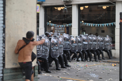 Integrantes de la Policía de Argentina se cubren durante un enfrentamiento con manifestantes por la reforma laboral, en Buenos Aires (Argentina).
