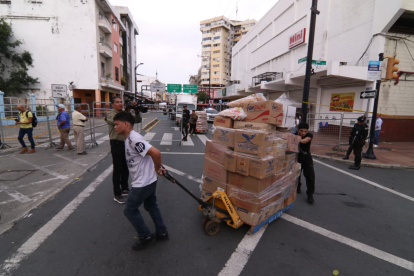 Comerciantes retiran su mercadería por la calle Eloy Alfaro.