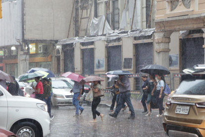 La lluvia en el centro de Guayaquil provocó que las personas busquen resguardarse.
