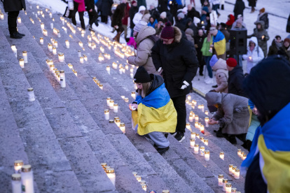 La gente enciende velas durante una manifestación que conmemora el cuarto aniversario de la invasión rusa en Ucrania. Helsinki, Finlandia, el 24 de febrero de 2026.