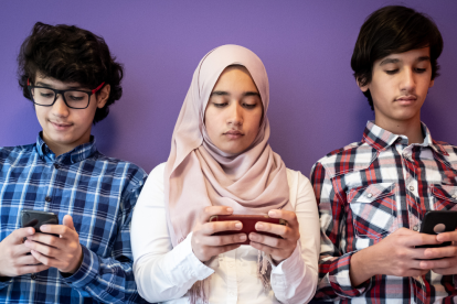 Referencial. Jóvenes conectados a sus teléfonos, en un contexto donde Indonesia limita el acceso a redes sociales para menores.