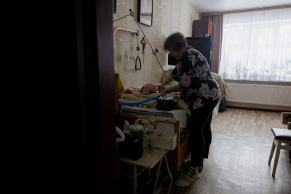 Olena Grygorenko junto a la cama de su esposo Anatoli Kuchynsky en Chernihiv el 12 de febrero de 2026, en medio de la invasión rusa de Ucrania.