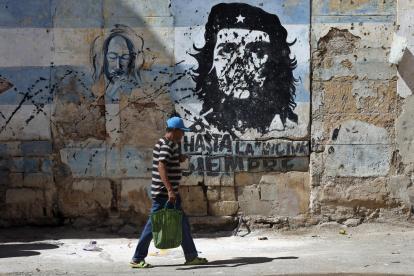 Una persona camina frente a un mural con la imagen de Ernesto 'Che' Guevara este jueves, en una calle de La Habana (Cuba).