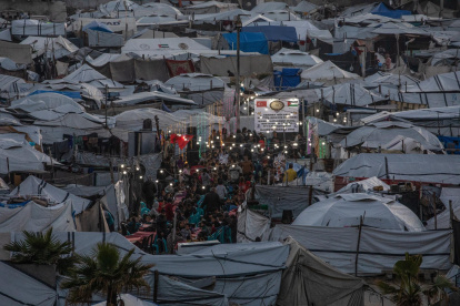 Palestinos desplazados se reúnen entre tiendas de campaña improvisadas para romper el ayuno durante el mes sagrado de ayuno de Ramadán, el 6 de marzo de 2026.
