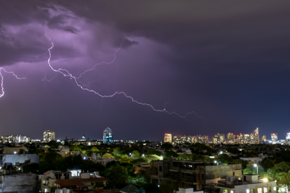 Referencial. Un rayo ilumina el cielo nocturno sobre la ciudad, mientras Inamhi advierte tormentas y lluvias en la Costa y Amazonía este 19 de febrero