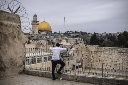 Israel. Un hombre judío ultraortodoxo reza frente al Muro Occidental cerrado, con vista al complejo de Al-Aqsa y a la Cúpula de la Roca de Jerusalén.