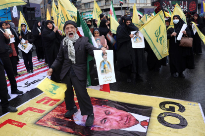 Un hombre iraní pisotea la imagen del primer ministro de Israel, Benjamin Netanyahu, durante una manifestación en Teherán, Irán, el 13 de marzo de 2026.