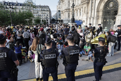 Policías frente a varias personas en una manifestación convocada por la asociación Utopía 56 en apoyo a varias familias sin hogar frente al ayuntamiento de París, el 5 de agosto de 2025