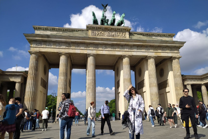 Personas caminan frente a la Puerta de Brandeburgo.
