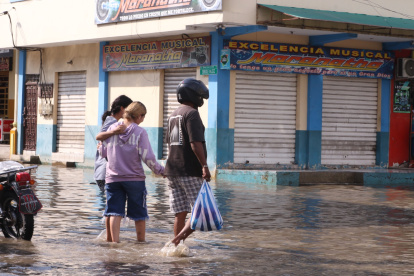 Las personas pasan las calles inundadas con miedo a no caerse en un hueco y los negocios permanecen cerradas