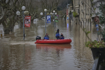 Miembros de la Gendarmería Nacional de Arcachon navegan en un bote inflable rojo en el río Garona inundado en La Reole, Nouvelle-Aquitaine, Francia, el 13 de febrero de 2026.
