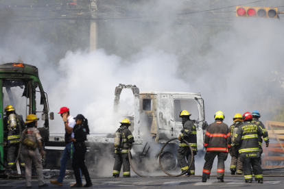Integrantes del Cuerpo de Bomberos de Guadalajara intentan apagar un vehículo incendiado este domingo 22 de febrero, tras el accionar de grupos narcodelictivos.