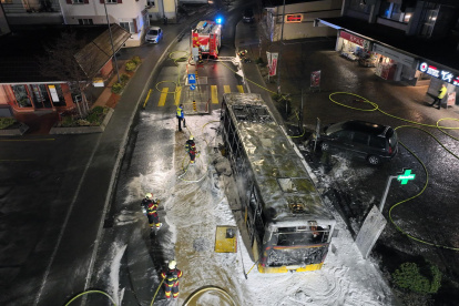 Investigadores examinando la carrocería carbonizada de un autobús postal en Kerzers, Suiza, el 10 de marzo de 2026.