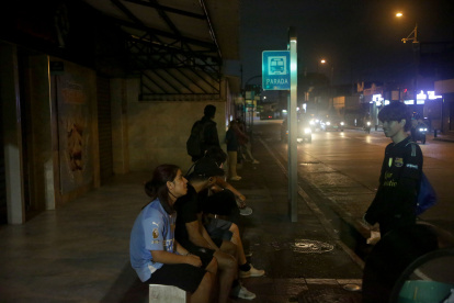 Jóvenes esperan casi una hora hasta que pase el bus que los lleve a su casa. Son las nueve de la noche.