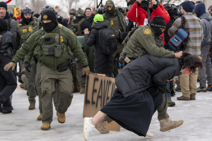 Un integrante de la Policía detiene a una persona durante las protestas en Mineápolis contra el Servicio de Inmigración y Control de Aduanas (ICE).