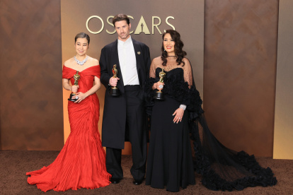 Maggie Kang (i), Chris Appelhans y Michelle L. M. Wong posan con el Óscar a mejor película de animación por K-Pop Demon Hunters este domingo.