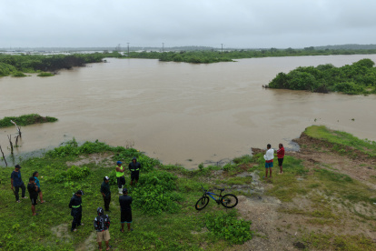 Fotografía aérea que muestra a personas observando las inundaciones en la localidad de Chanduy en Santa Elena.
