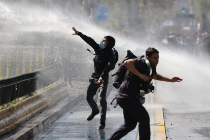 Manifestantes e integrantes de la Policía de antidisturbios de Carabineros de Chile se enfrentan durante una manifestación el 26 de marzo de 2026, en Santiago (Chile).