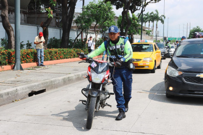 Un agente de tránsito traslada un motocicleta retenida en la avenida Pedro Menéndez Gilbert, este martes 3 de marzo.