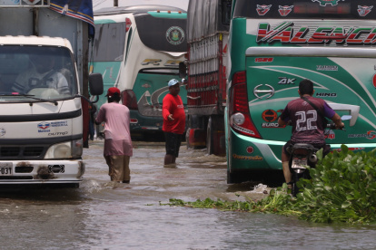 En la vía Babahoyo Jujan hay personas que se dedican de guía para que los carros no caigan en huecos
