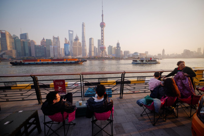 Fotografía de archivo de un grupo de personas frente al paisaje urbano de Shanghai.