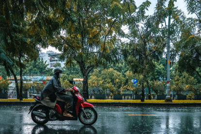 Referencial.Un motociclista circula bajo la lluvia, mientras el Inamhi advierte sobre precipitaciones dispersas y alta radiación este 13 de marzo.