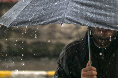 Referencial. Un ciudadano se protege de la lluvia con un paraguas, mientras el Inamhi advierte de precipitaciones y tormentas eléctricas en varias provincias del país hasta el 25 de marzo.